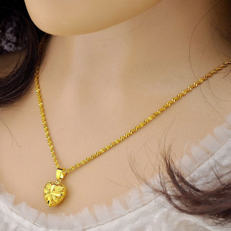 Minimalist gold heart pendant necklace on a delicate chain worn on the neck