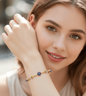 Woman wearing a gold bracelet with a blue stone on a blurred background
